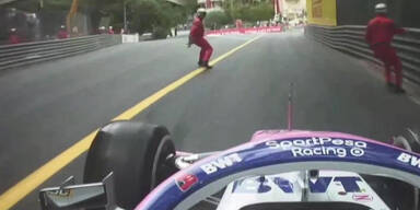 Streckenposten laufen vor Formel-1-Auto