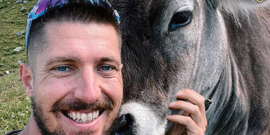 Marcel Hirscher mit einer Kuh und nacktem Oberkörper