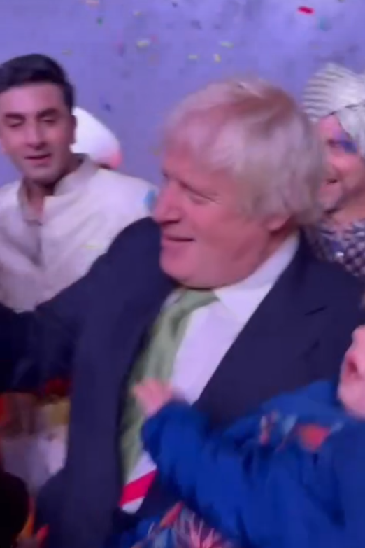 Boris Johnson tanzt mit seinem Baby im Arm.