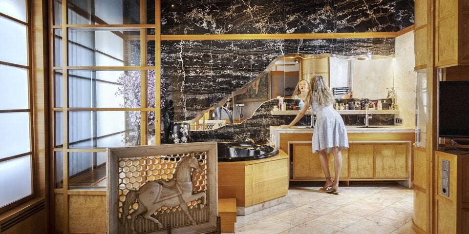 Das in das Schlafzimmer integrierte Bad mit schwarzem Marmor, Edelholz und Lichtdusche ist eines von vier Badezimmern.  