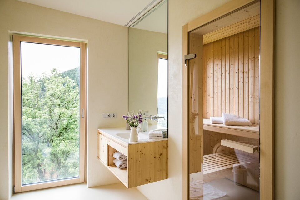 Von der Küche bis zum Bad: Holz dominiert in dem Kleinod unter Bäumen und jede Ecke spiegelt die Liebe der Besitzer zur Natur wider.   