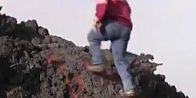 Mann l&auml;uft &uuml;ber flie&szlig;enden Lavastrom