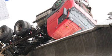 Lastwagen kippt über Brückenrand