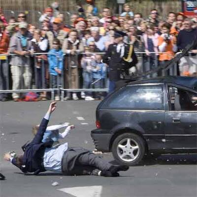 Auto rast bei Parade in Zuschauer