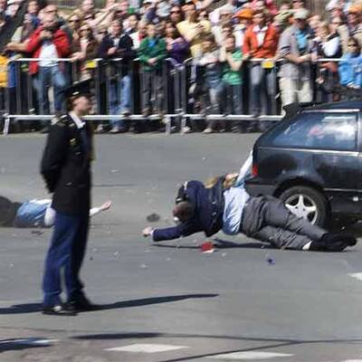 Auto rast bei Parade in Zuschauer