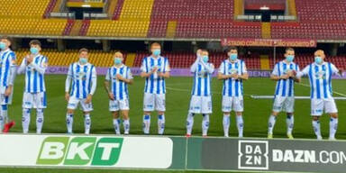 Italienisches Team l&auml;uft mit Schutzmasken ein