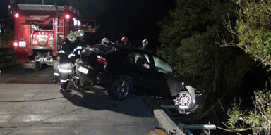 Unfallauto hängt halb von der Brücke