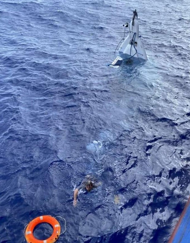 Hier klammert sich ein Segler an sein sinkendes Boot