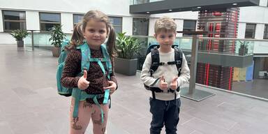 Kinder sollen Schultasche probieren.