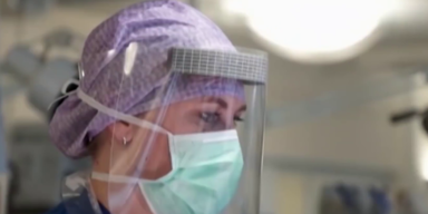 Pflegerin mit Maske und Schild