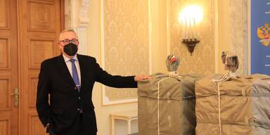 Mitarbeiter der russischen Botschaft mit Sputnik V-Paket