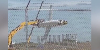 Bagger hebt Flugzeug